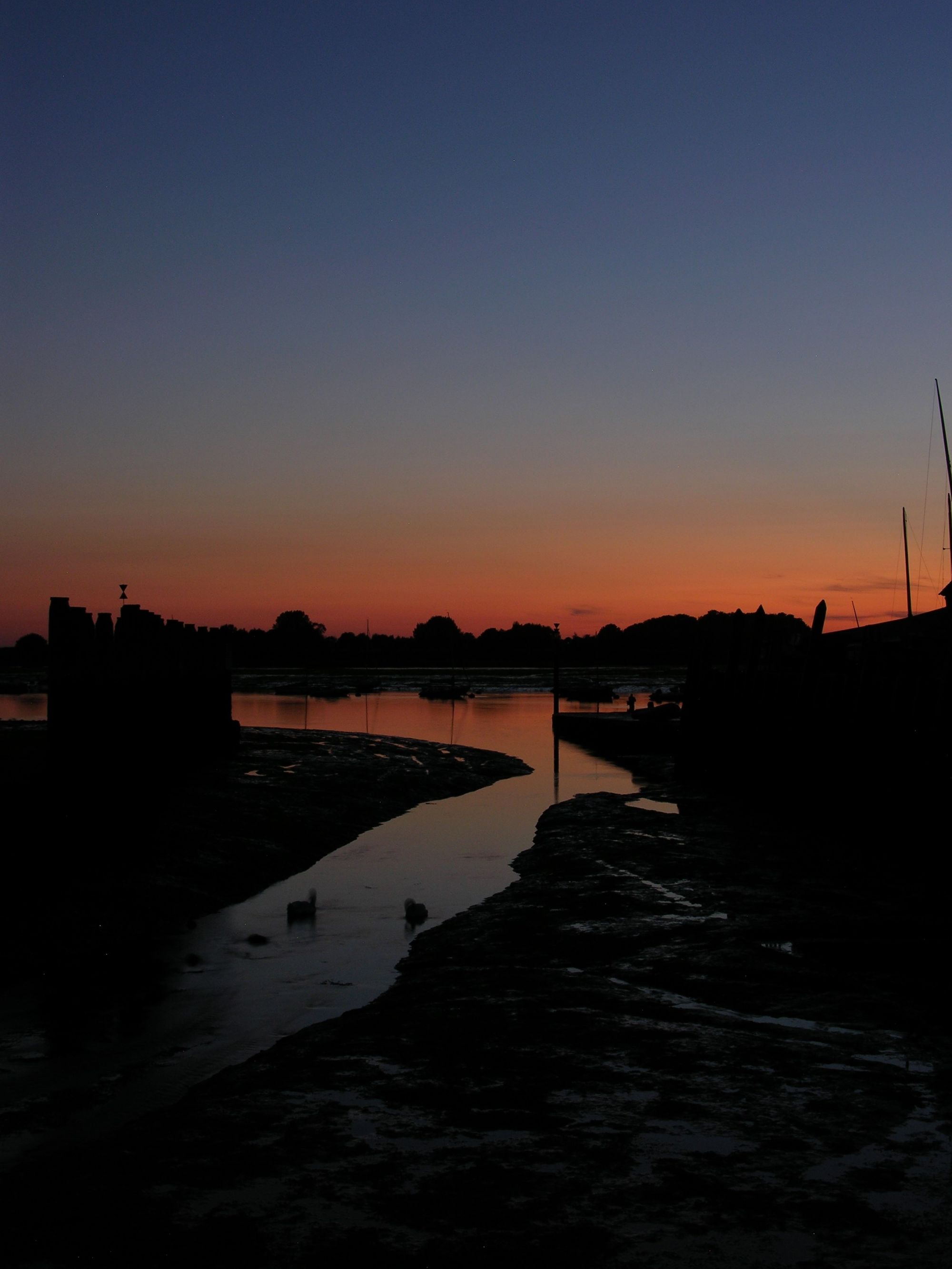 A river leading out to sea at sunset.