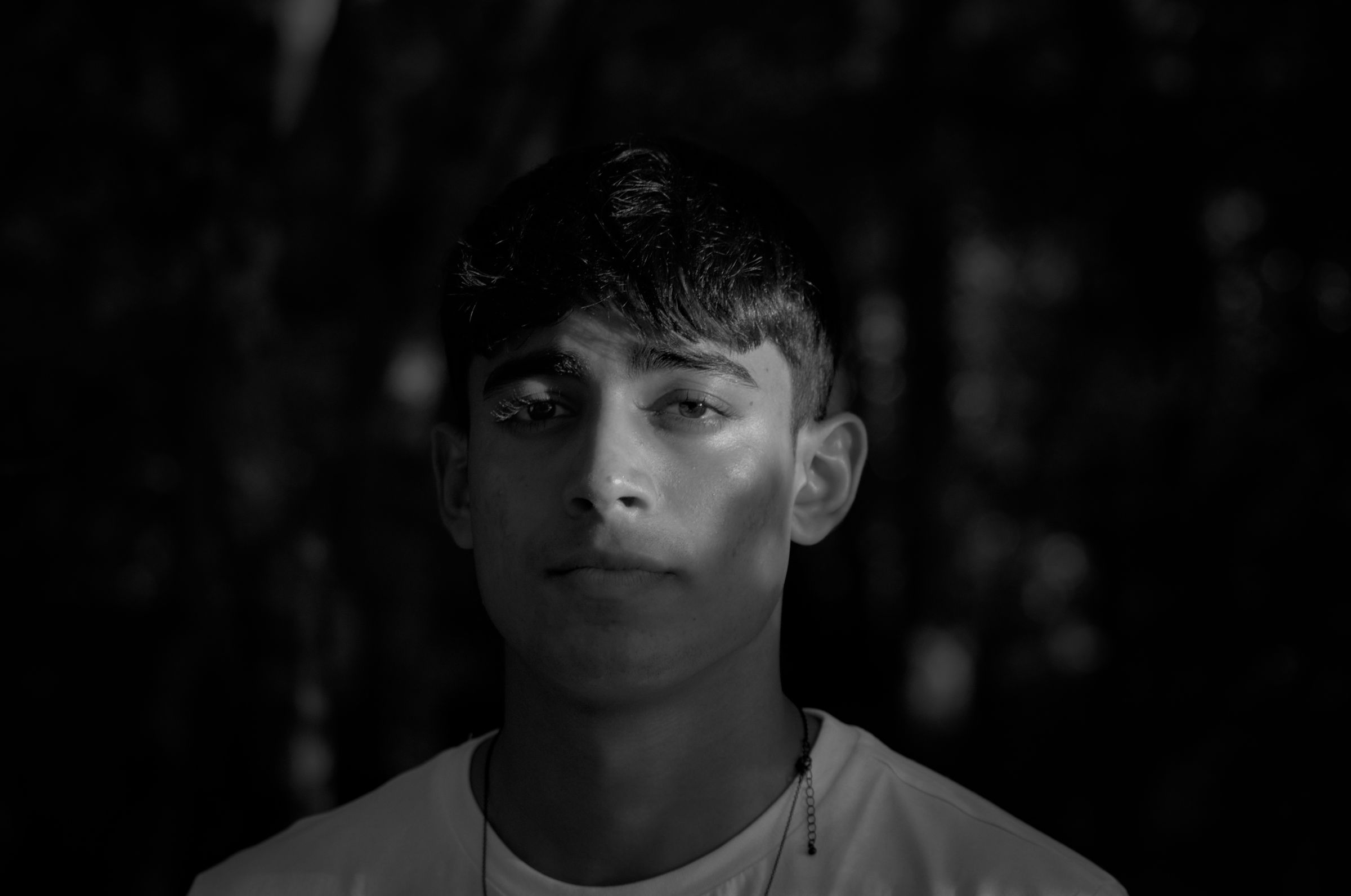 Black and white portrait photo with sunlight shining on one half of the face.