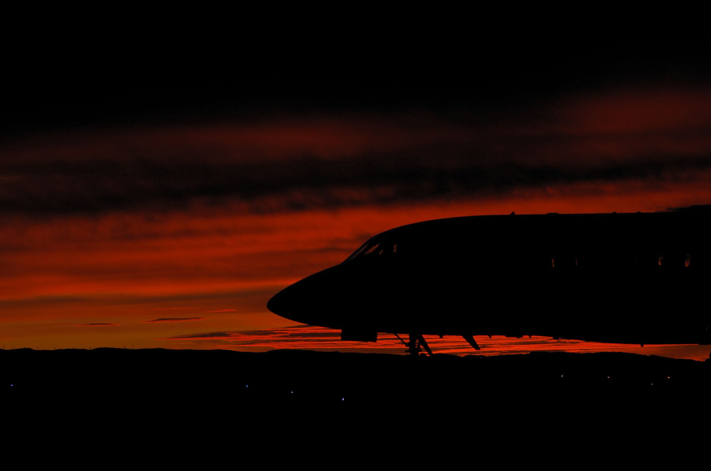 A Bombardier Challenger jet at Dundee Airport, viewed from the side at sunset.